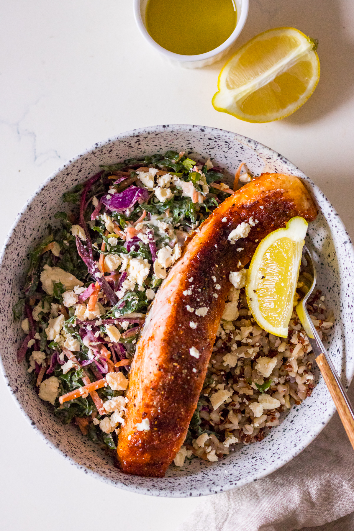 Brown sugar baked salmon fillet in a speckled bowl with slaw and rice