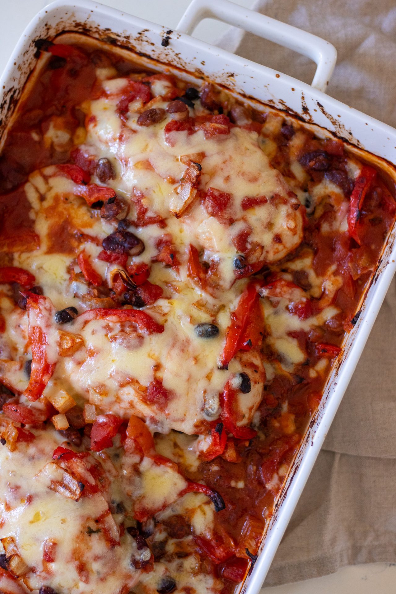 Top view of healthy chicken taco bake with black beans and capsicum in a baking dish