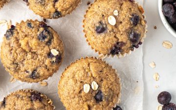 Healthy banana blueberry oat muffins arranged on a white counter.