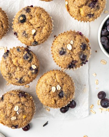 Healthy banana blueberry oat muffins arranged on a white counter.