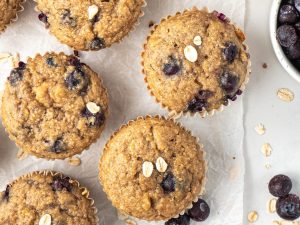 Healthy banana blueberry oat muffins arranged on a white counter.