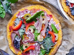 A healthy paleo pumpkin pizza crust recipe using mashed pumpkin, almond flour and psyllium husk. It's grain free and dairy free, and can be made vegan using a flax egg!