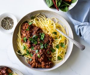 Red Wine Bolognese in ceramic bowl, spaghetti, parsley garnish