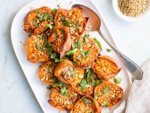 smashed sweet potatoes with dukkah on white serving platter