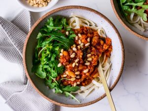 Vegan bolognese sauce topped with pine nuts